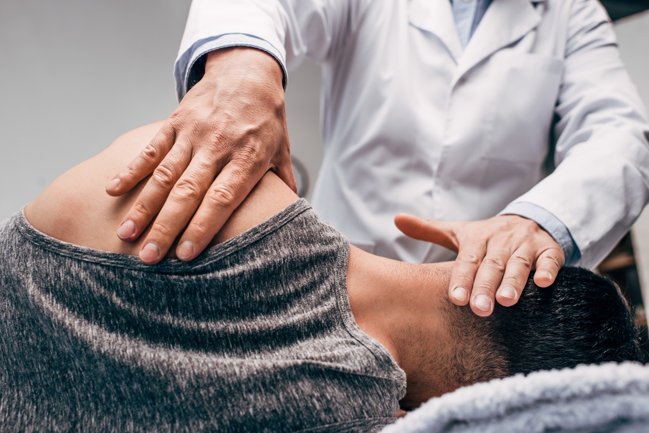 chiropractor in white coat massaging neck of man chiropractor in white coat massaging neck of man
