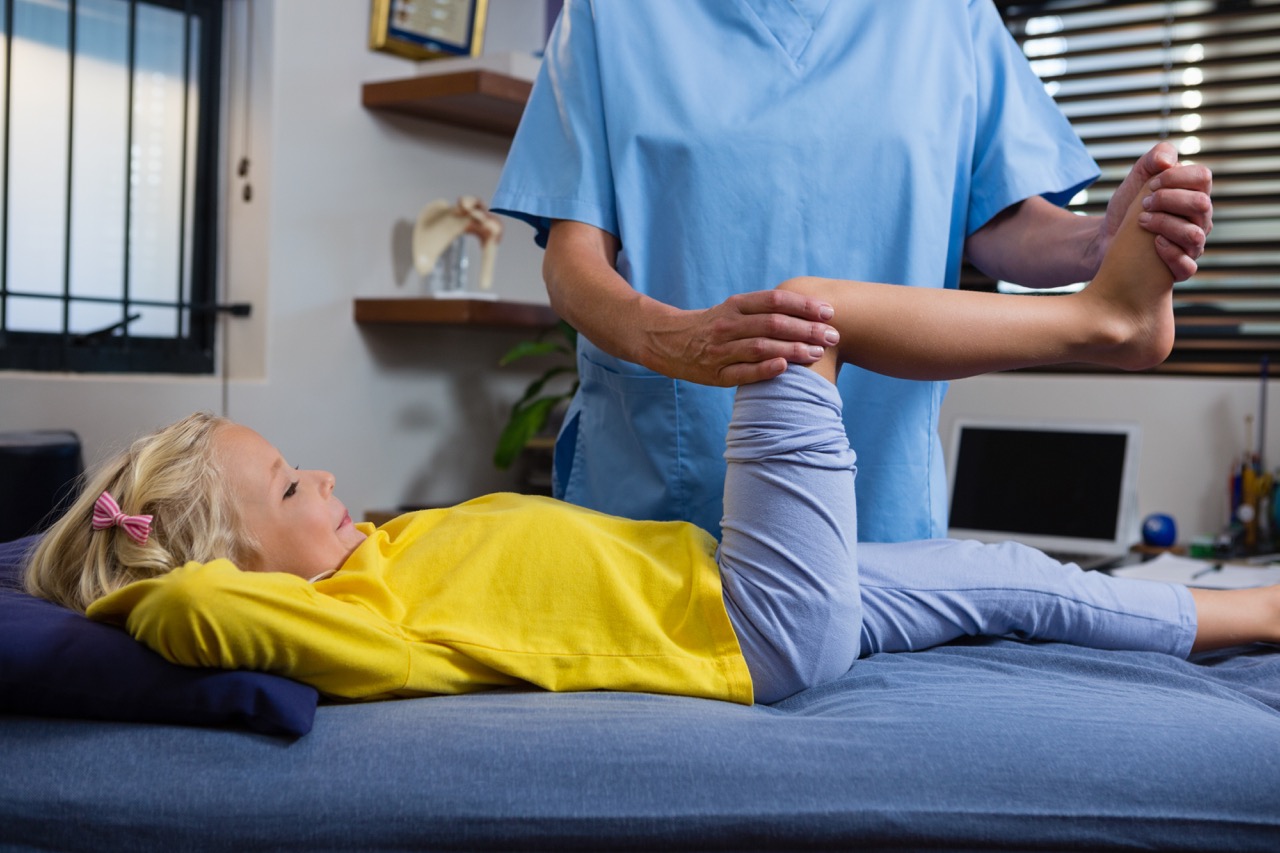 Physiotherapist giving physical therapy to the girl in hospital